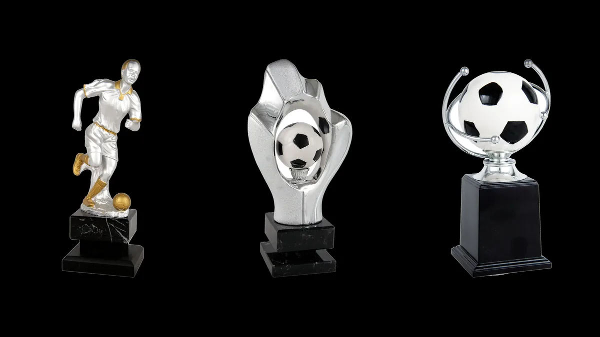 Trofeos de futbol: figura de jugador y balones plateados